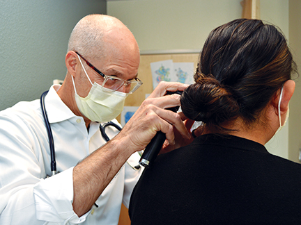 Dr. Chip Roser assesses a patient in the Center for Global Health & Healing in Boise, Idaho.