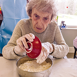 An elderly woman does some baking
