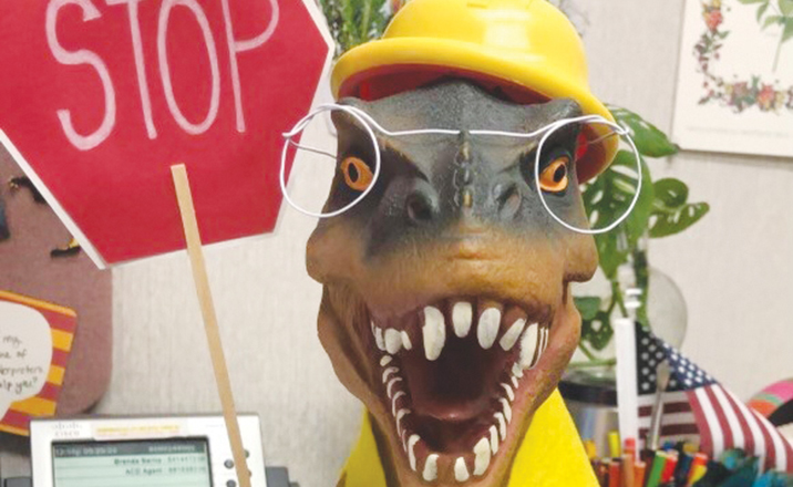 A dinosaur dressed as a crossing guard.