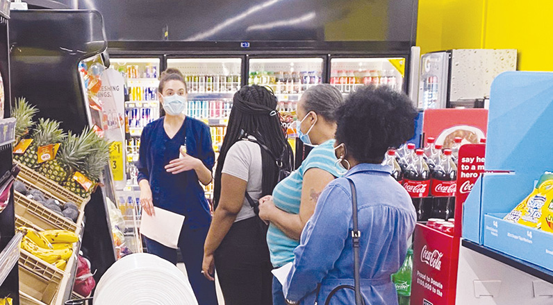 Nurse Lindsay Barleycorn leads a grocery tour at a Dollar General store with several women.