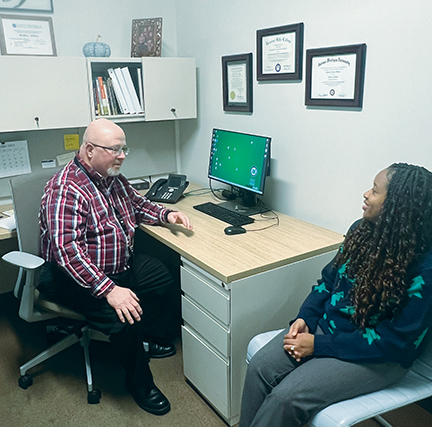 Rev. Rodney Adkins speaks with Yvette Rearden, a family navigator, regarding support they can offer to a patient at the Provider Response Organization for Addiction Care and Treatment in Huntington, West Virginia.