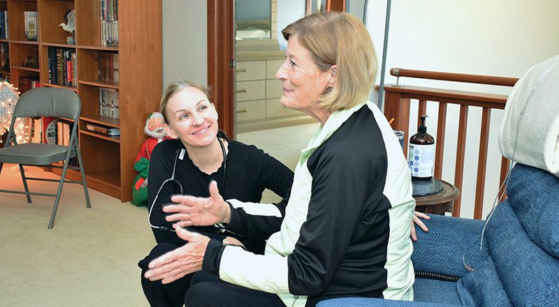 Vice president and medical director of care transitions and medical director for hospital at home, listens to a patient.