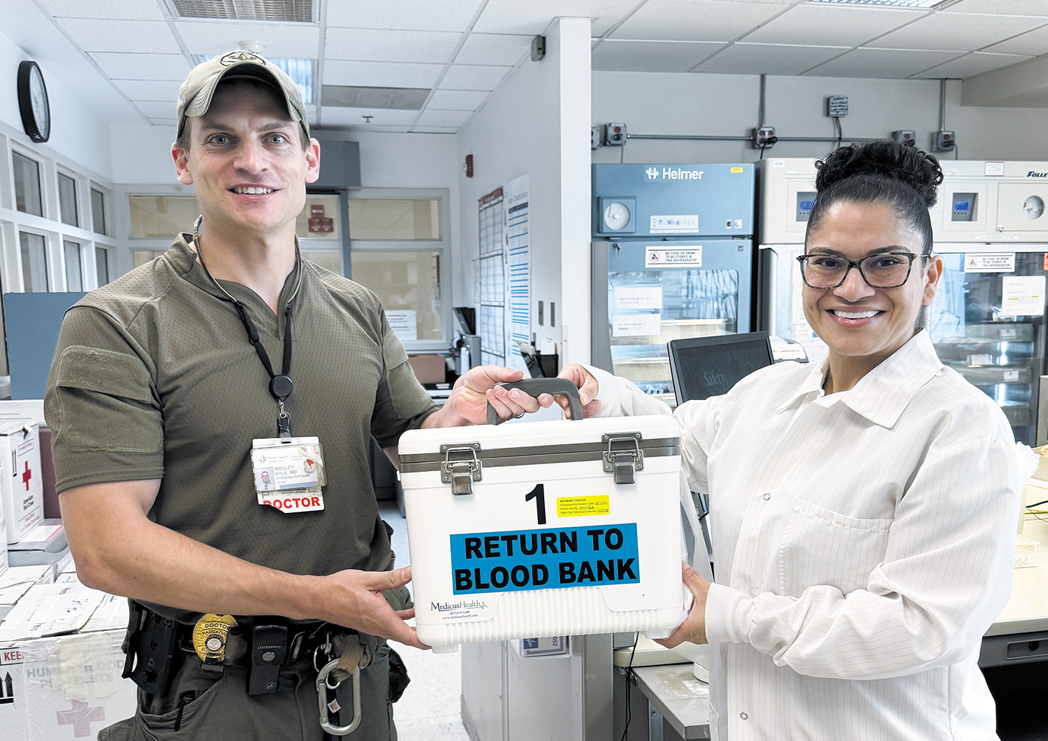 Kyle and Kelly Mojica of Saint Mary’s Blood Bank hold a specialized cooler that transports blood in ambulances. Kyle is on duty with Greater Waterbury SWAT as a medic.