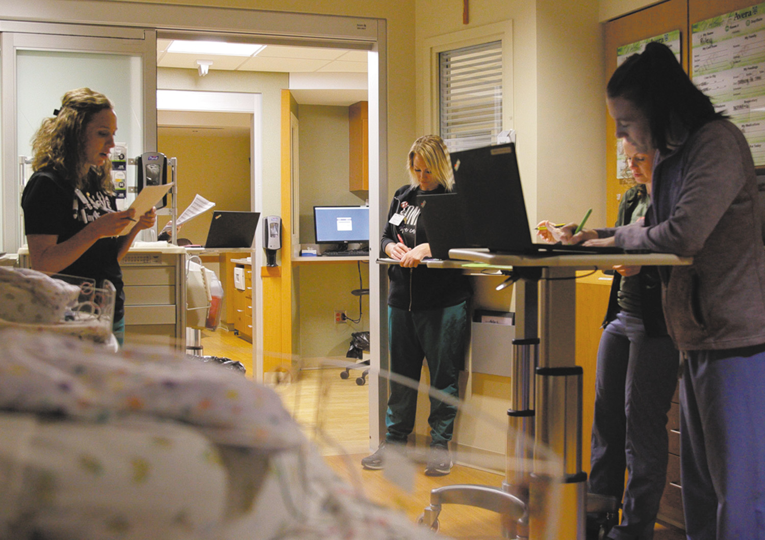 Nurse Kelsey McCarty, left, delivers a patient update during rounding with the care team in the neonatal intensive care unit of Avera McKennan Hospital & University Health Center.