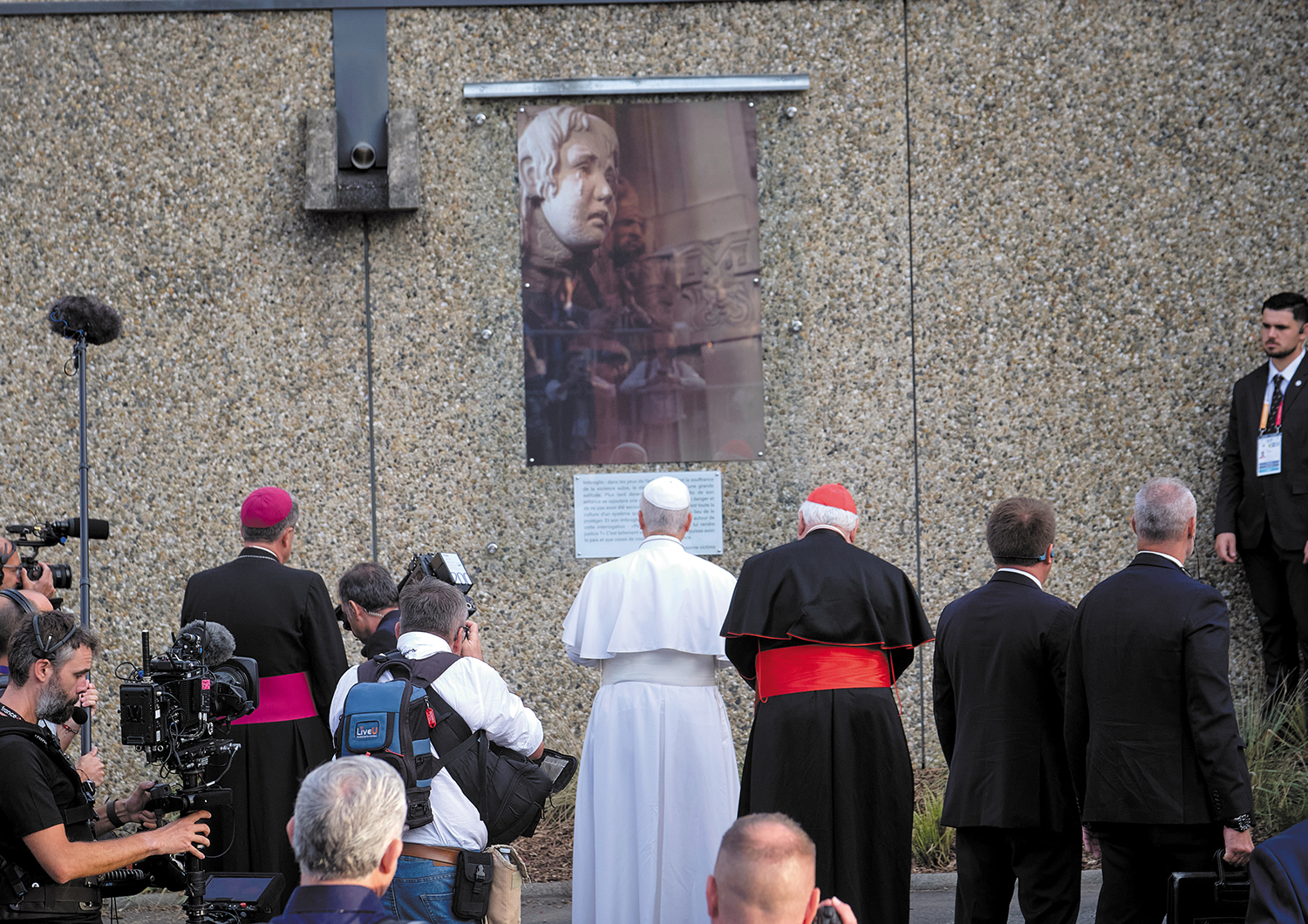 Pope Leo XIV and clergy walk past a portrait at the Sanctuary of Our Lady of Lourdes in Lourdes, France, during a September visit.